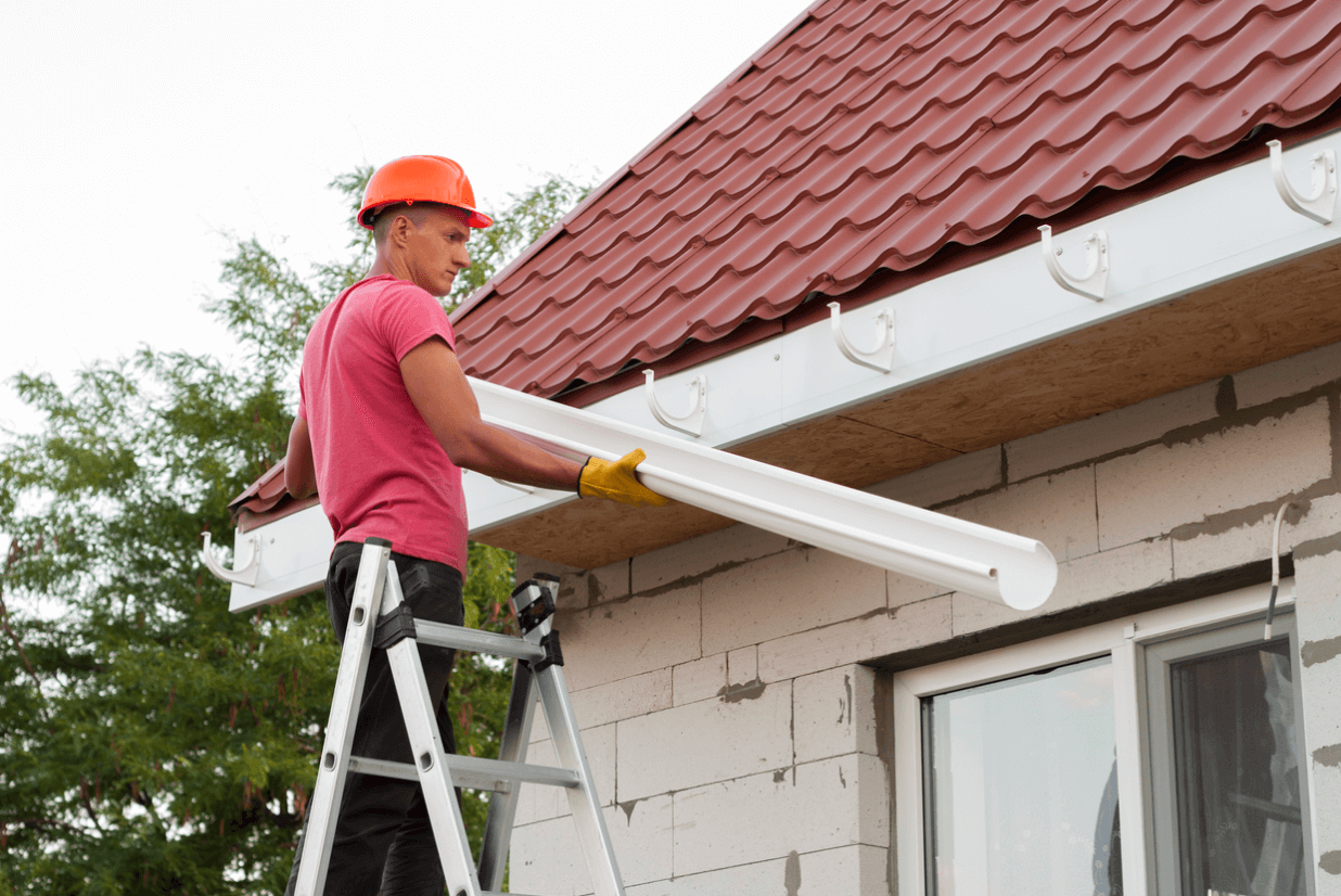 Professional installing gutters on home
