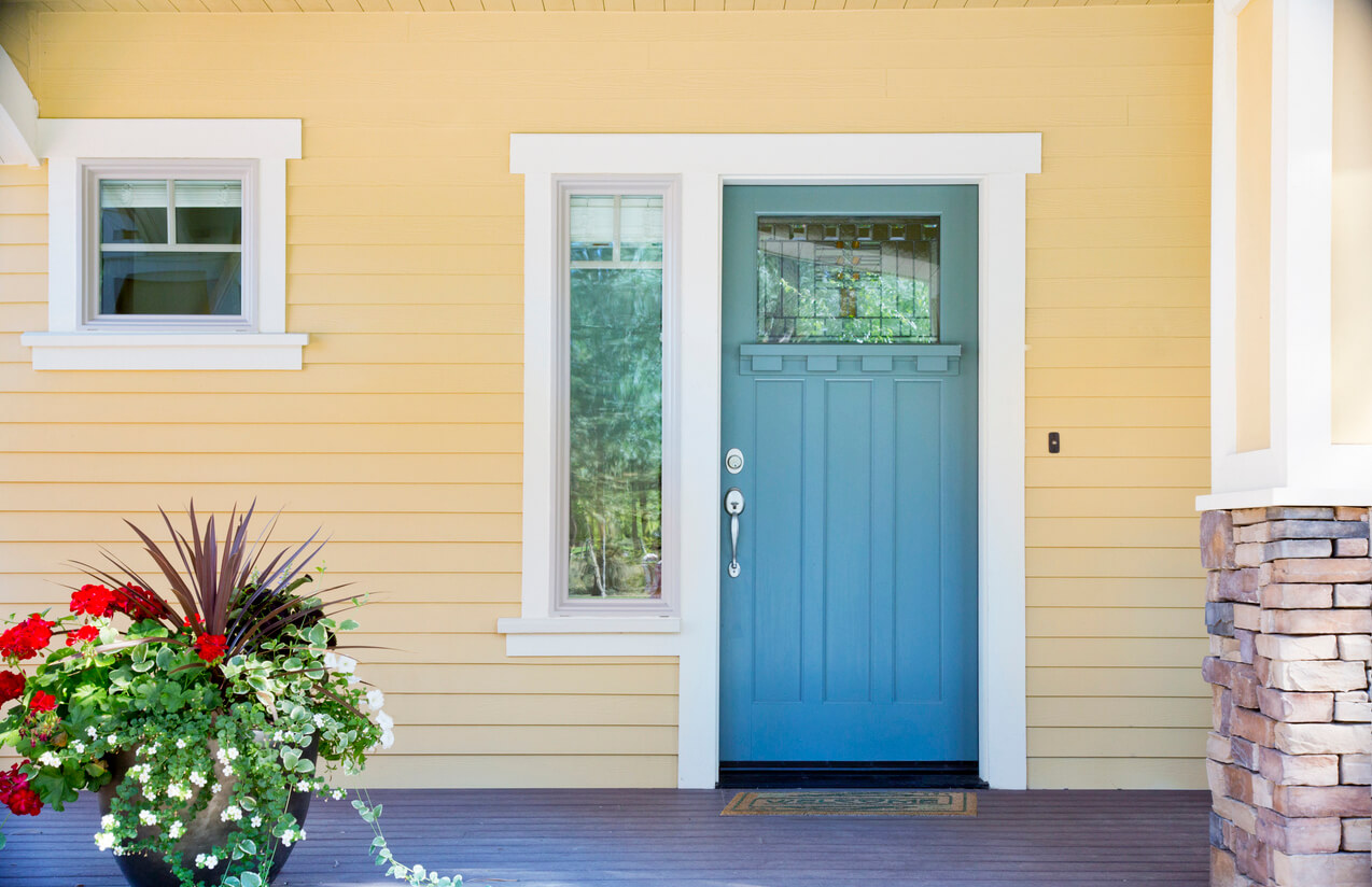Close up of a yellow house with a bright blue door