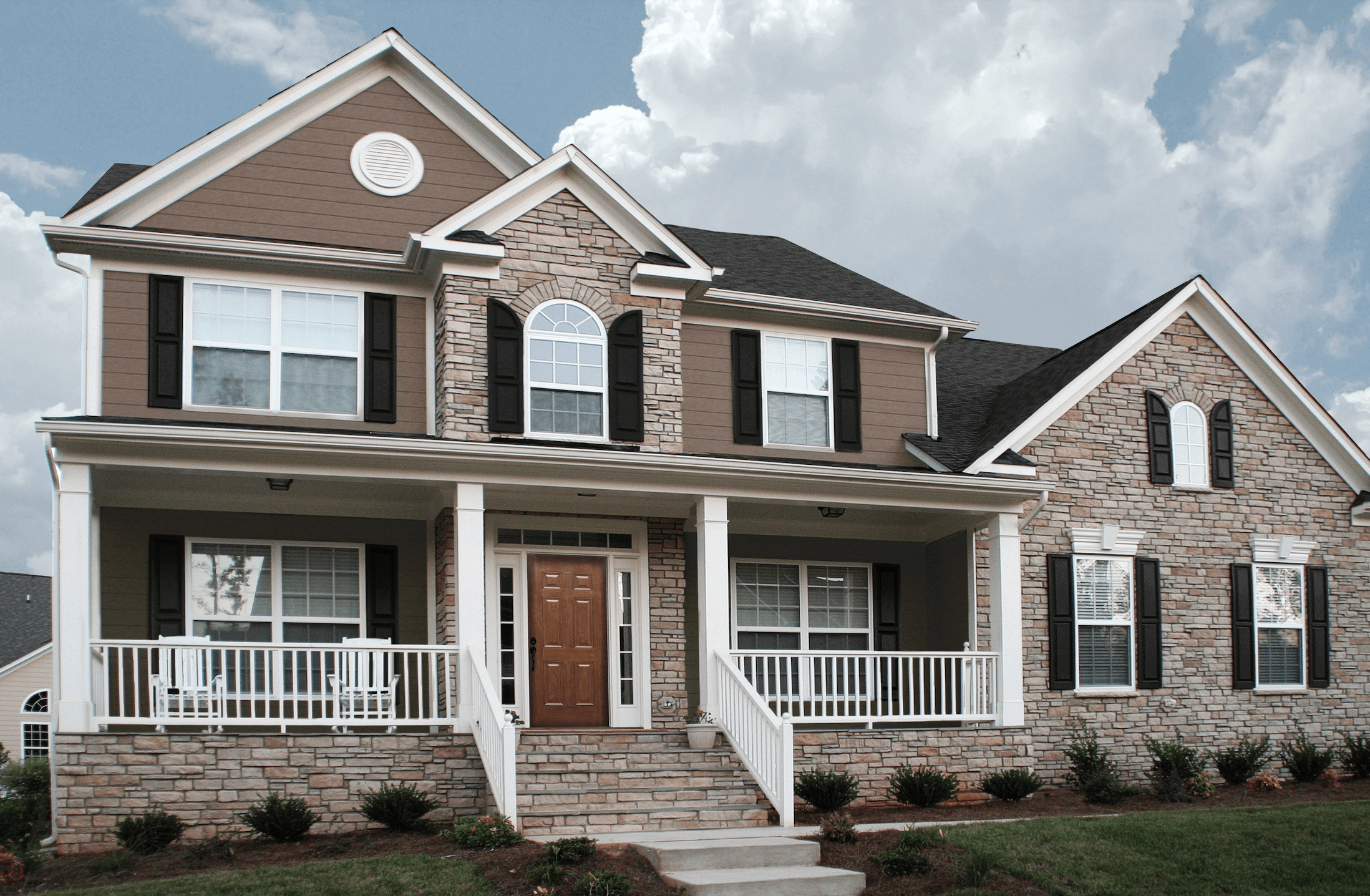 home with manufactured stone siding across the front mixed with brown vinyl siding.