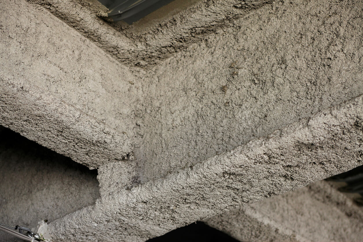 gray spray foam insulation on metal beams in an old commercial building