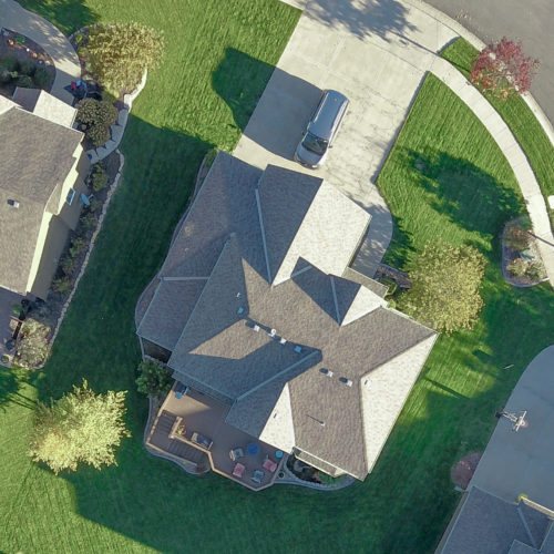Overhead drone photo of a large house showcasing a roof inspection
