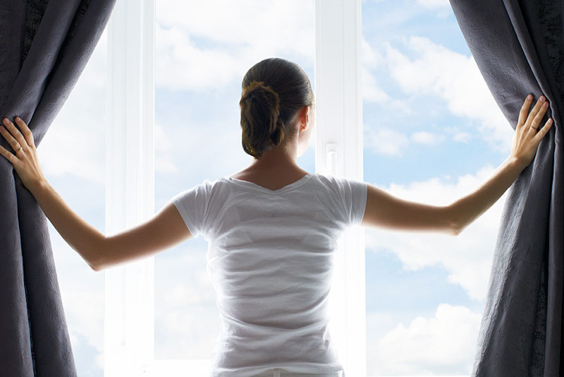woman looking outside from behind double glazed windows
