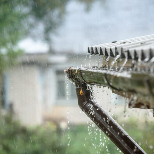 Up close roof and gutters during rainfall